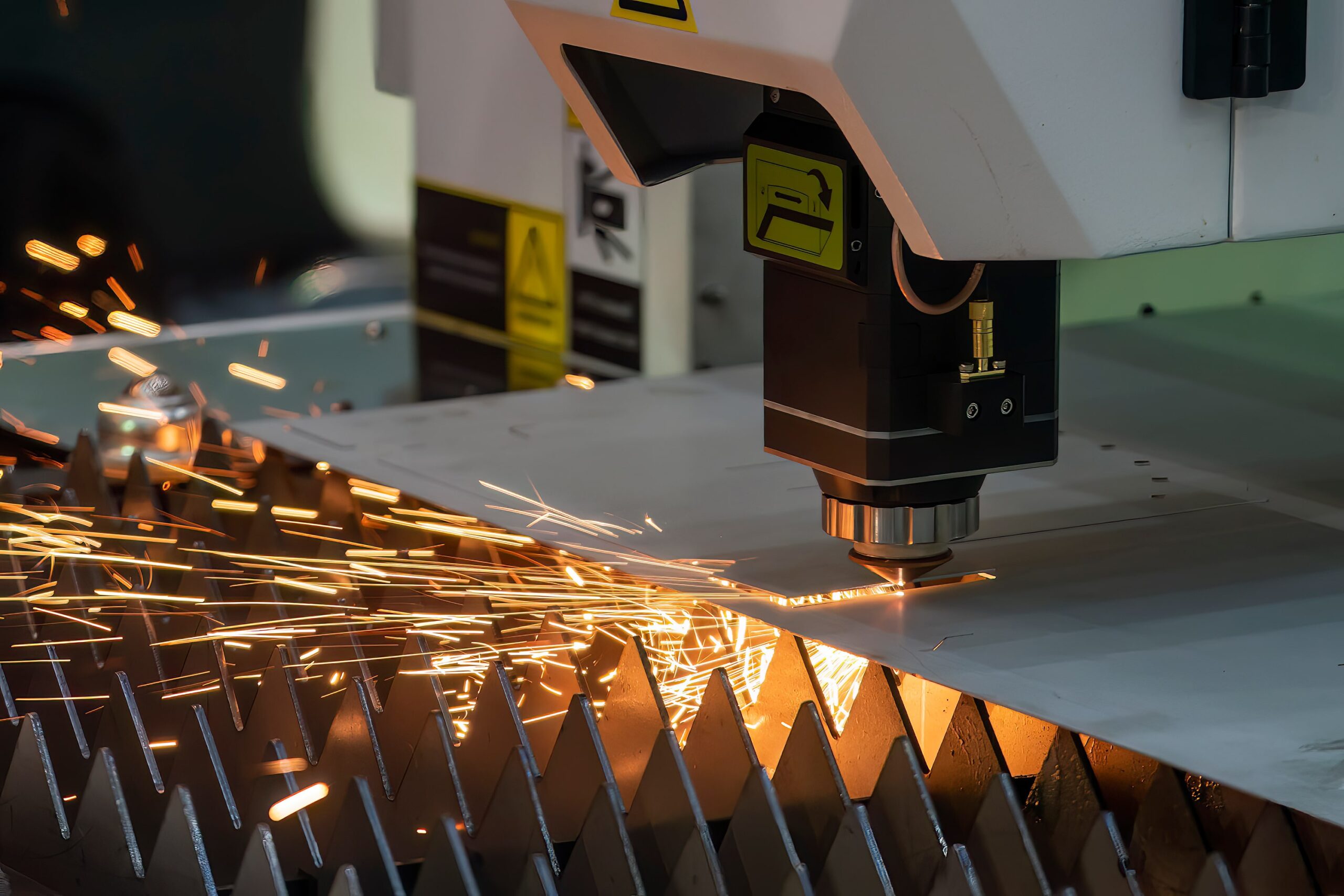 Machine undergoing laser and plasma cutting with sparks flying, showcasing the importance of a fume extractor and dust collector.